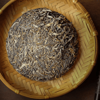 forest pu'er tea from Naka village, Yunnan, China, stone-pressed for collection, shengpu in leaves detail and knife