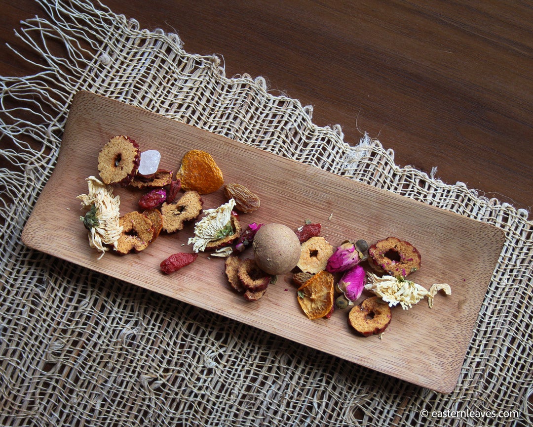 Eight treasures Chinese herbal tea with longan, chrysanthemum, rose blossoms, tangerine peel, jujubes, goji berries, raisins, rock sugar