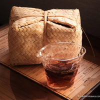 Tianjian cha dark black tea, fermented, in original bamboo leaf basket; 2014 harvest from China in glass server