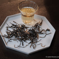 Pu'er shengpu Chinese tea loose-leaf vintage and aged, 2017 spring harvest, from ancient trees forest, yellow brew liquor in glass cup, golden buds, from Nannuo in Yunnan