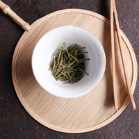 Anjibaicha Chinese green tea from Zhejiang, China, in infused loose-leaf with white porcelain gaiwan teaware from Jingdezhen, green bamboo coaster and bamboo clamps
