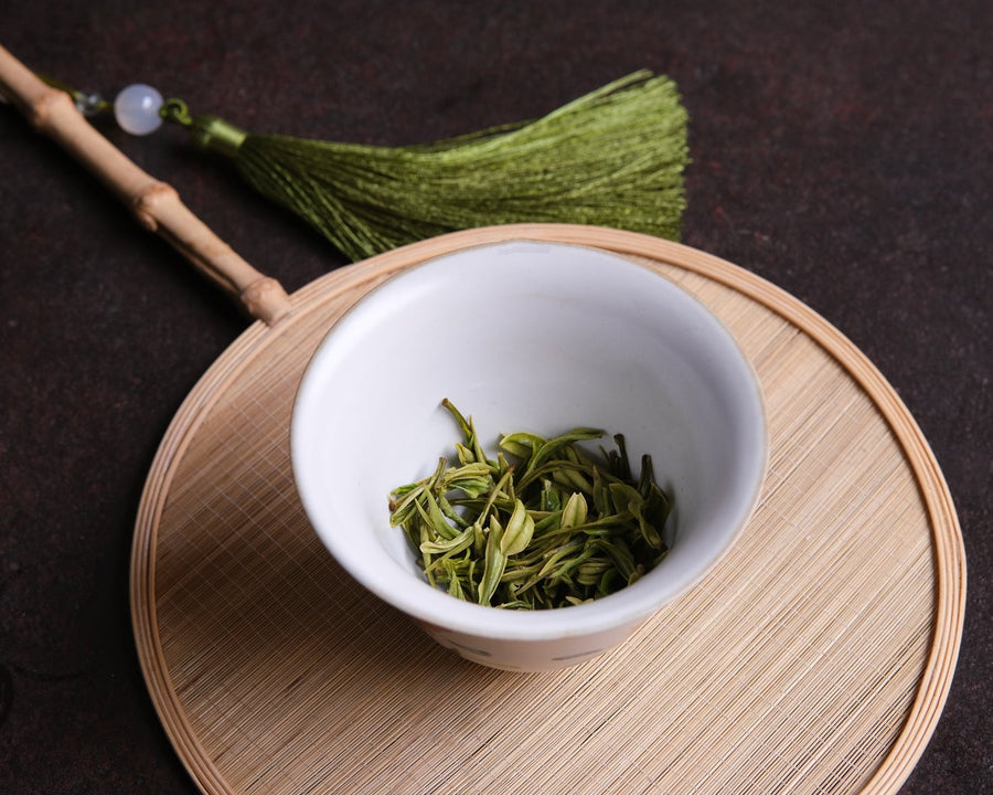 Anjibaicha Chinese green tea from Zhejiang, China, in infused loose-leaf with white porcelain gaiwan from Jingdezhen and green bamboo coaster