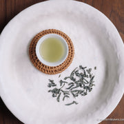 Chinese green tea from Yunnan, Dianlu, loose-leaf with white porcelain cup and coaster from Jingdezhen - dry leaves detail