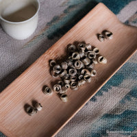 Chinese green and flower Jasmin scented tea, in ring bamboo shape, Nuerhuan rare loose-leaf tea detail on bamboo tray with cup