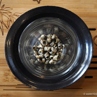 Chinese green and flower Jasmin scented tea, in ring bamboo shape, Nuerhuan rare loose-leaf tea detail in glass cup and bamboo